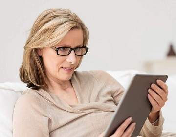 beautiful woman in her fifties thinking about early retirement as she uses Cook and Companys Rule 72t calculator