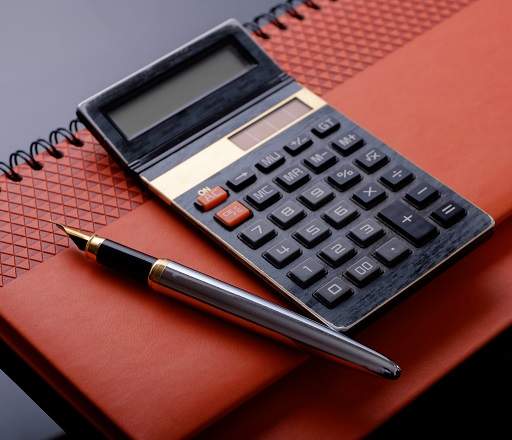 calculator and pen on desk calendar